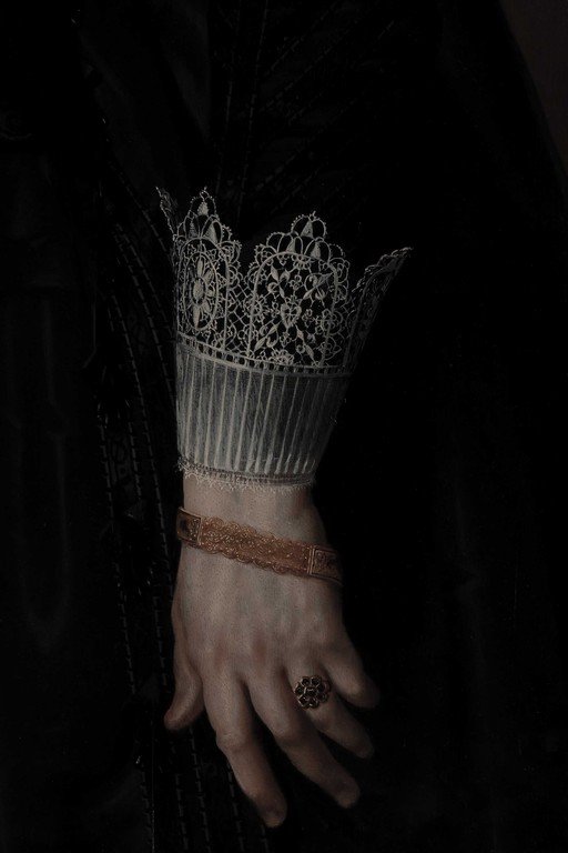 Ornate Lace Cuff and Decorative Ring on Pale Hand