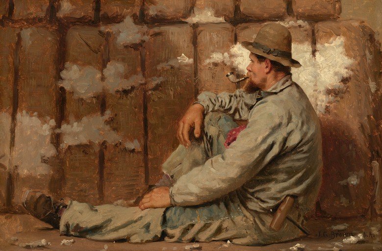 Man Smoking Pipe Amidst Cotton Bales