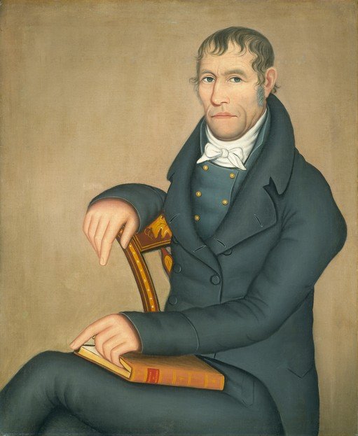 Portrait of a Man in a Dark Coat with a Book