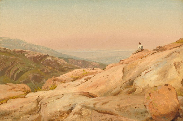 Man Sitting on Rocky Outcrop Overlooking a Valley