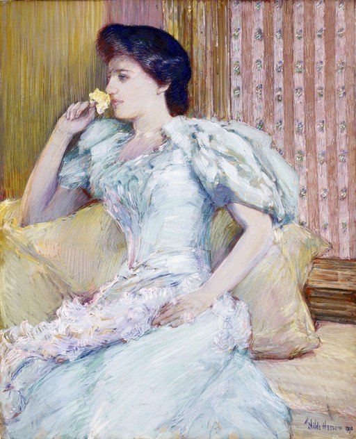 Woman in a White Dress Smelling a Yellow Flower