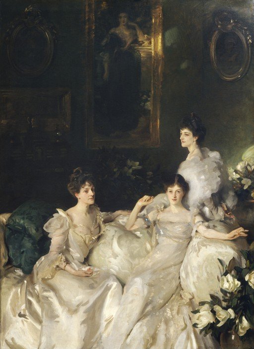 Elegant Women in White Gowns on a Sofa
